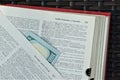 Hundred dollar bill tucked into dictionary page at `health insurance`