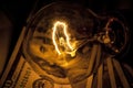 Rising electricity prices. Old light bulb and dollar bills Royalty Free Stock Photo