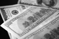 Hundred dollar bills on a dark background, black and white Royalty Free Stock Photo