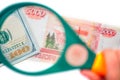 Hundred dollar under a magnifying glass on the bacdrop of ruble banknotes Royalty Free Stock Photo