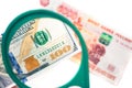 Hundred dollar under a magnifying glass on the bacdrop of ruble banknotes Royalty Free Stock Photo
