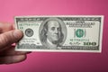 A hundred dollars close-up in hand on a pink background Royalty Free Stock Photo