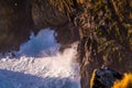 Hundreds of sea birds perch on the rocks above the crashing waves