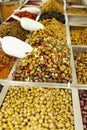 Hundreds of traditional Italian green olives, multiple types. Huge olive heap at a local market stall Stack of different olives