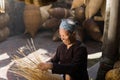Hung Yen, Vietnam - July 9, 2016: Female craftsman making traditional bamboo fish trap at her old house in Thu Sy trade village