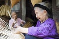 Hung Yen, Vietnam - July 26, 2015: Old woman weaves bamboo fish trap at Vietnamese traditional crafts village Thu Sy, Hung Yen pro