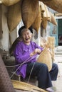 Hung Yen, Vietnam - July 26, 2015: Old woman weaves bamboo fish trap at Vietnamese traditional crafts village Thu Sy, Hung Yen pro