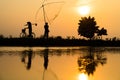 Hung Yen, Vietnam - July 9, 2016: Vietnamese rural countryside sunset scene with silhouette farmers carrying bamboo fish traps hom