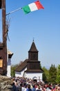 Hungarian flag over old church in an old traditional village - Holloko, Hungary