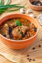 Hungarian goulash with prunes in bowl on wooden background