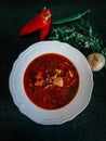 Hungarian Goulash soup with pepper in a white plate on a dark background Royalty Free Stock Photo