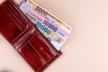 Hungarian HUF banknotes spread out and leather wallet on a yellow background