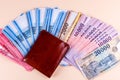 Hungarian HUF banknotes spread out and leather wallet on a yellow background.