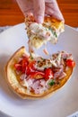 Hungarian pancakes langos with ham and cheese close-up on the table