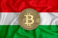 Hungary flag, bitcoin gold coin on flag background. The concept of blockchain, bitcoin, currency decentralization in the country. Royalty Free Stock Photo