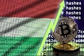 Hungary flag and rising green arrow on bitcoin mining screen and two physical golden bitcoins Royalty Free Stock Photo