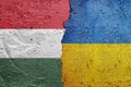 Hungary and Ukraine - Cracked concrete wall painted with a Hungarian flag on the left and a Ukrainian flag on the right stock