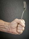 Hungry and angry male hand holding fork Royalty Free Stock Photo