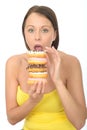 Hungry Attractive Young Woman Holding a Pile of Iced Donuts