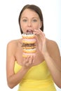 Hungry Attractive Young Woman Holding a Pile of Iced Donuts Royalty Free Stock Photo