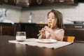 Hungry beautiful little girl is eating tasty cheesecake with fork for lunch