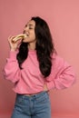 Hungry beautiful young dark-haired Caucasian woman snacking on an appetizing nutritious sandwich in front of the camera Royalty Free Stock Photo