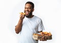 Hungry Black Guy Eating Pizza Holding Box Standing In Studio