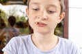 A hungry boy eating a fried potatoes on the summer terrace of the city fast food restaurant, close up view Royalty Free Stock Photo
