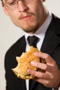 Hungry businessman eating hamburger