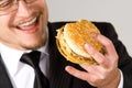 Hungry businessman eating hamburger