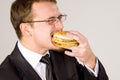 Hungry businessman eating hamburger