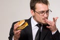 Hungry businessman eating hamburger