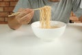Casual Thai man uses chopsticks to eat instant noodles in a white cup Royalty Free Stock Photo