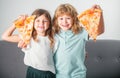 Hungry children eating pizza. Happy excited children eating pizza and having fun together. Happy kids holding pizza