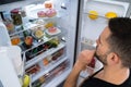 Hungry Confused Man Looking In Open Fridge Royalty Free Stock Photo