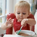 Hungry, cute and baby eating porridge for health, nutrition or child development at home. Food, sweet and girl toddler Royalty Free Stock Photo