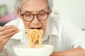 Hungry elderly woman eating instant noodles,fast food junk food High Sodium,Campaign for a low sodium diet,concept of healthy Royalty Free Stock Photo