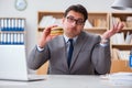 The hungry funny businessman eating junk food sandwich