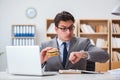 The hungry funny businessman eating junk food sandwich