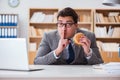 The hungry funny businessman eating junk food sandwich