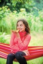 Hungry girl eating pizza slice sit hammock, summer picnic concept