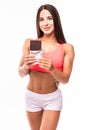 Fitness woman interrupted her diet. Portrait of young sports girl eating chocolate bar while isolated on white background.