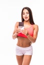 Fitness woman interrupted her diet. Portrait of young sports girl eating chocolate bar while isolated on white background.