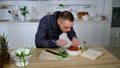 A hungry guy sneaked into the kitchen and began to eat salad