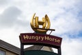 A Hungry Horse restaurant logo on a signboard outside a pub