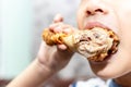 Hungry little boy eating chicken leg. Child hand holding a fried chicken