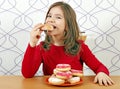 Hungry little girl eat donuts
