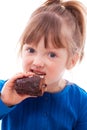 Hungry little girl eating cake