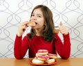 Little girl eats sweet donuts Royalty Free Stock Photo