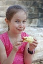 Hungry Little Girl Portrait Eating Red Apple Outdoor Healthy Snack for Kids Bite the Fruit Apple. girl in Pink Dress. Royalty Free Stock Photo